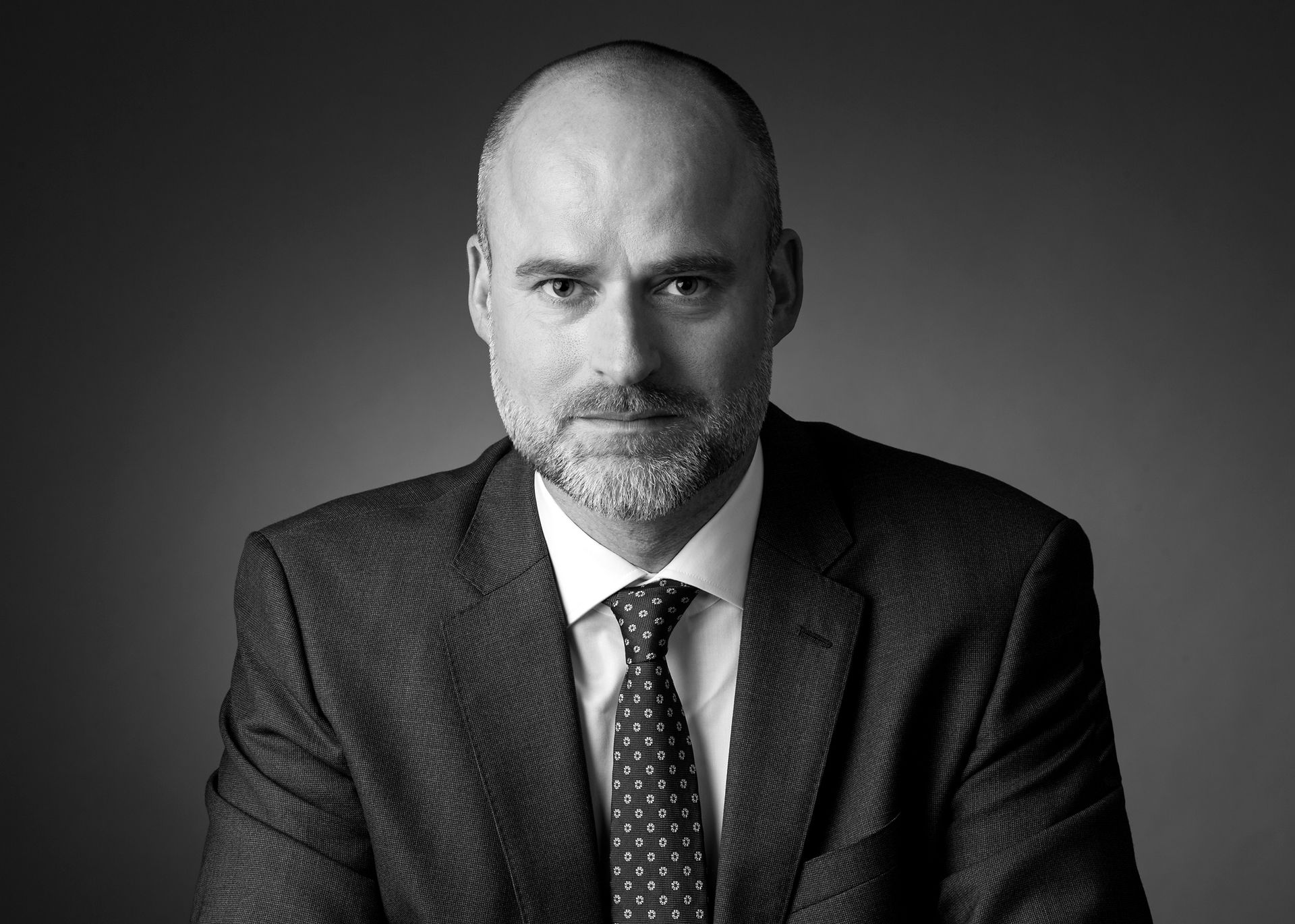 Lutz Happich als Operating Partner steht souverän in einem modernen Büro, präsentiert Projektpläne und kommuniziert mit einem Team. Sein Auftreten verkörpert die Werte eines erfahrenen Projektmanagers: Verlässlichkeit, Zielorientierung und Effizienz. Das Bild vermittelt Kompetenz, Führung und die sichere Generierung von Mehrwerten für Kunden – ideal für Unternehmen, die nachhaltige Projekterfolge und messbare Ergebnisse suchen.